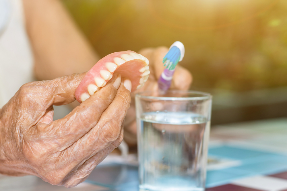 older woman cleaning dentures