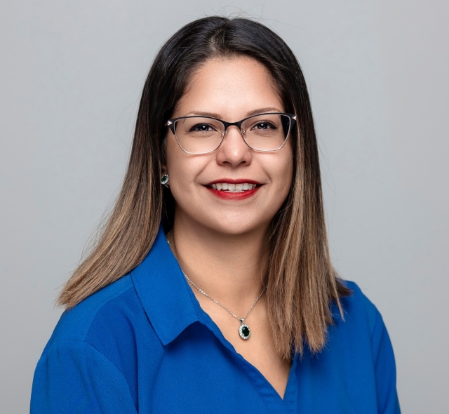 Estrellita, office manager at Robles Family Dental, smiling in a blue shirt with glasses and necklace, representing the dental team serving Berwyn, Cicero, Riverside, North Riverside, and Lyons.