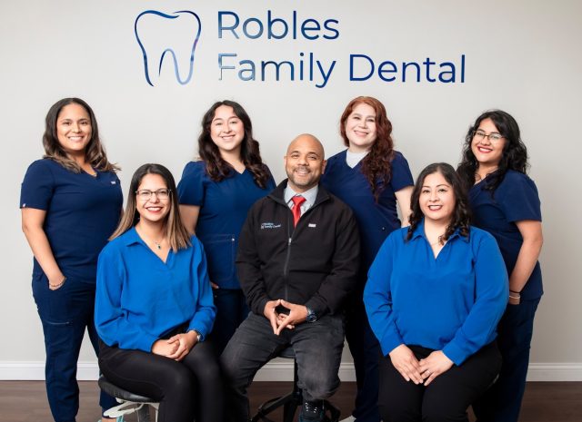 Robles Family Dental team in blue scrubs, featuring Dr. Kenny Robles at the center, promoting comprehensive dental care for families in Berwyn, IL.