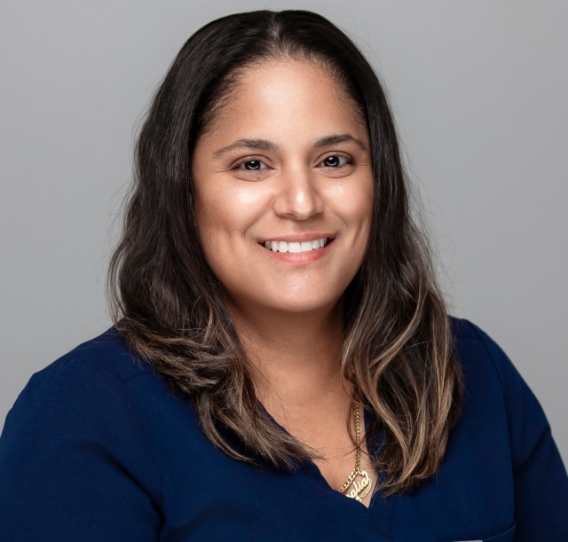 Dental hygienist Rosalia smiling in a blue uniform, representing Robles Family Dental's staff.