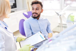 Patient discussing dental anxiety with dentist in a modern dental office, emphasizing open communication and comfort during dental visits.